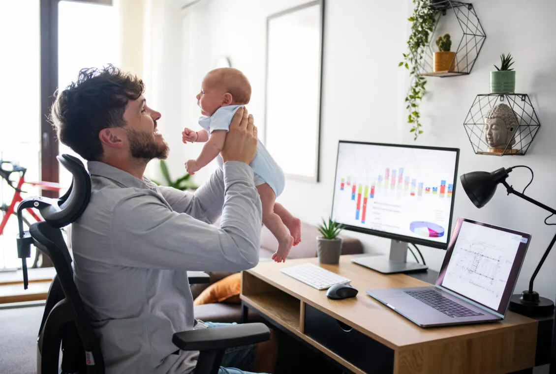 Vater betreut sein Baby, während er im Homeoffice arbeitet